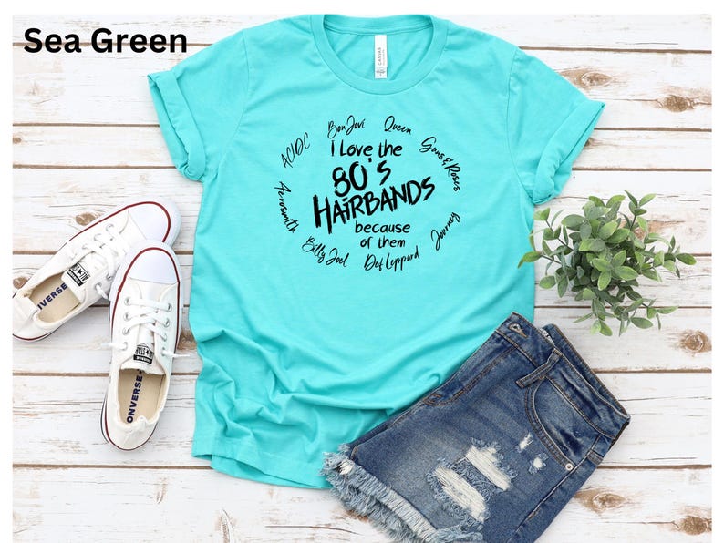 Peut inclure: T-shirt vert d'eau avec le texte "I love the 80's Hairbands because of them" et des noms de groupes en cercle. Comprend une paire de baskets blanches et un short en jean.