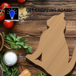 Pode incluir: Uma tábua de cortar de madeira em forma de gato sentada em uma superfície de madeira com vários alimentos ao redor. O texto "CAT CHOPPING BOARD" é visível na parte superior da imagem.