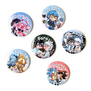 May include: A collection of six round buttons with colorful anime-style illustrations. Each button features different characters and phrases like "Doomed Yaoi," "Yaoi Jesus," and "Grumpy Sunshine." The buttons are on a white background.