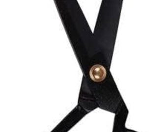May include: Black scissors with a gold-colored rivet. The scissors have large finger holes and long, sharp blades. The blades are angled and meet at a point. The scissors are likely used for cutting fabric or paper.
