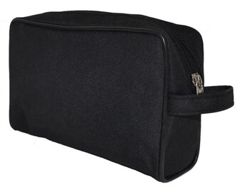 Può includere: Un beauty case rettangolare nero con chiusura a zip e una piccola maniglia laterale. La borsa è realizzata in tessuto strutturato e ha un bordo nero.