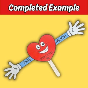 Puede incluir: Un letrero rojo en forma de coraz&oacute;n con una cara sonriente y el texto "JESUS LOVES ME". El letrero tiene brazos con manos que dicen "THIS MUCH". El letrero est&aacute; sobre un palo de madera, con las palabras "Completed Example" en la parte superior.