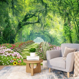 Könnte beinhalten: Ein grauer Sessel mit einer braunen Wolldecke steht vor einem Foto-Wandbild, das einen steinernen Weg zeigt, der mit rosa und weißen Blumen gesäumt ist und durch einen üppigen grünen Wald führt.