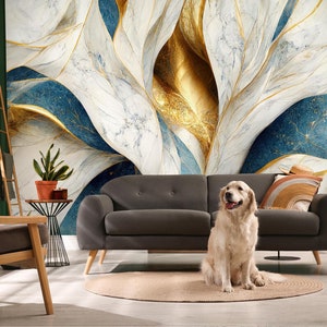 May include: A grey sofa with a golden retriever dog sitting on it. The sofa is in front of a wall with a large abstract painting featuring blue, white and gold colours.
