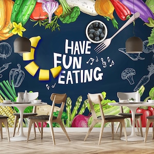 May include: A chalkboard wall mural with a hand-drawn illustration of various fruits and vegetables. The text "Have Fun Eating" is written in white on the chalkboard. Two wooden chairs and a white table are in front of the chalkboard.
