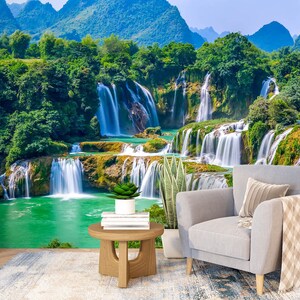 Könnte beinhalten: Ein Landschaftsfoto mit einem üppigen grünen Wald und einem Wasserfall, der über mehrere Stufen herabstürzt. Das Wasser ist kristallklar und das umliegende Grün ist lebendig. Das Bild eignet sich perfekt für eine naturbezogene Wanddekoration.