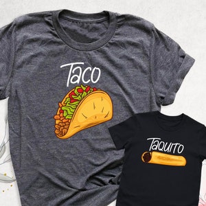 May include: A gray t-shirt with the word "Taco" and a cartoon taco on it. A black t-shirt with the word "Taquito" and a cartoon taquito on it.