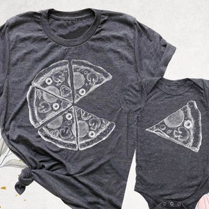May include: A matching set of gray t-shirts with a white pizza graphic. The larger shirt has a whole pizza with four slices missing, while the smaller shirt has a single slice of pizza.