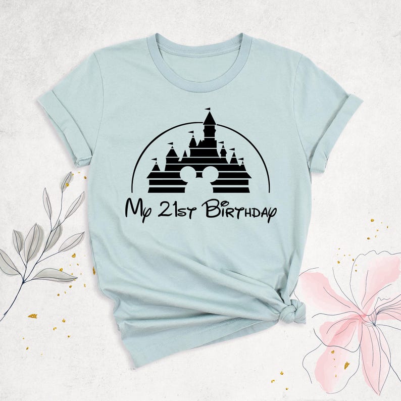 May include: Light blue t-shirt with a black silhouette of the Disney castle and the text "My 21st Birthday".