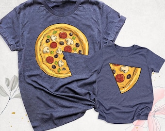 May include: Two heather navy blue t-shirts. The larger shirt features a graphic of a whole pizza with a missing triangular slice. The smaller shirt features a graphic of a single triangular pizza slice that matches the missing piece.