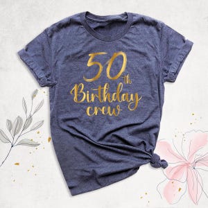 May include: A navy blue t-shirt with gold lettering that says "50th Birthday Crew".
