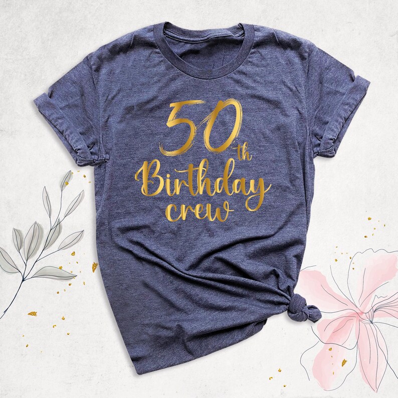 May include: A navy blue t-shirt with gold lettering that says "50th Birthday Crew".