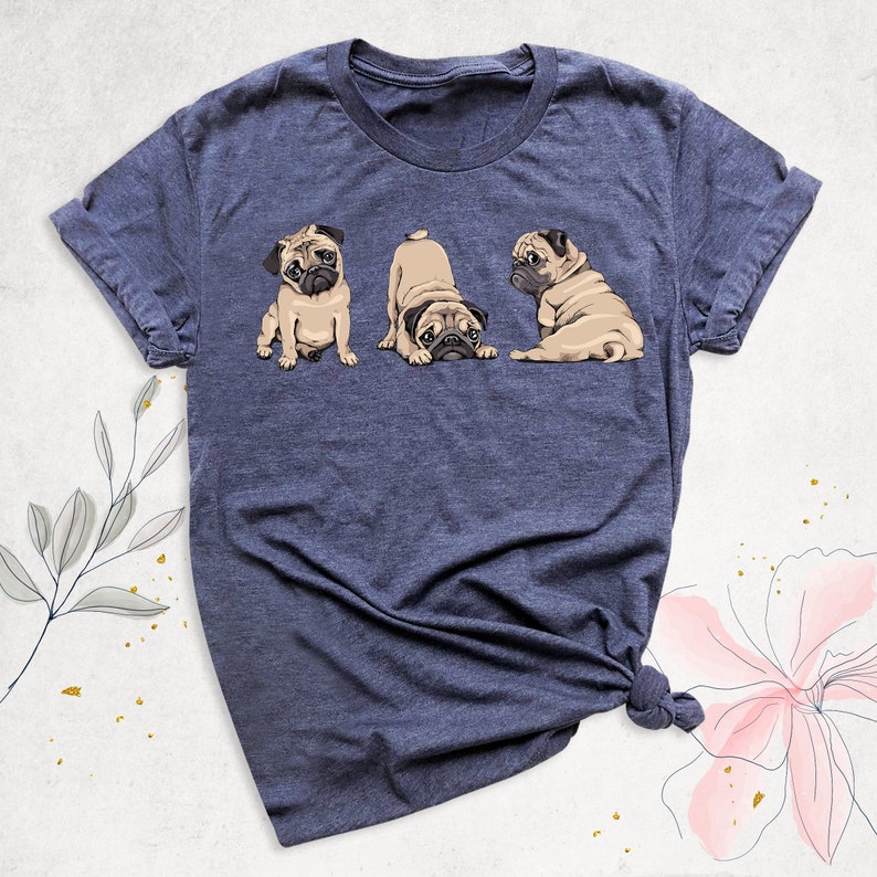 May include: A navy blue t-shirt with a graphic of three pugs. The pugs are in different poses, one is sitting, one is looking back, and one is looking forward.