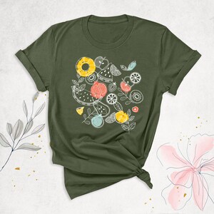 May include: A green t-shirt with a white graphic of various fruits and vegetables, including watermelon, pineapple, kiwi, and strawberries.
