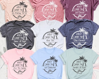 May include: A collection of nine short-sleeved t-shirts in various colors, each featuring a circular graphic with palm trees, a ship's wheel, and a cruise ship. The text Most Likely To is printed above custom phrases like Be Making TikTok, Drink Margarita, Get Seasick, Dance All Night, Your Text, Sing Karaoke, Kiss The Captain, Get Sunburned, and Gamble All Night.