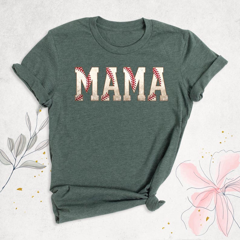 May include: A green t-shirt with the word "MAMA" printed on it in white letters. The letters are outlined with a red baseball stitch design.