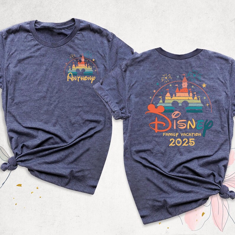 K&ouml;nnte beinhalten: Zwei marineblaue T-Shirts mit einem Retro-Disney World-Schloss-Motiv. Das vordere Shirt hat den Namen "Anthony" unterhalb des Schlosses gedruckt. Das hintere Shirt hat den Text "Disney Family Vacation 2025" unterhalb des Schlosses gedruckt.