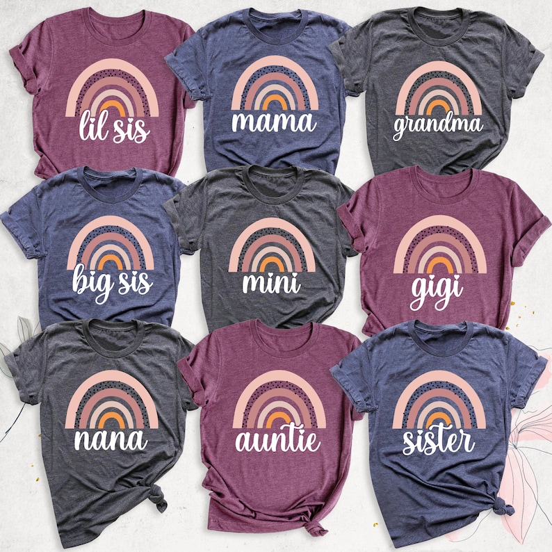 Pode incluir: Nove camisetas diferentes com um design de arco-&iacute;ris e v&aacute;rios textos. O texto nas camisetas inclui "lil sis", "mama", "grandma", "big sis", "mini", "gigi", "nana", "auntie" e "sister".
