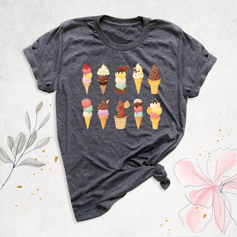 May include: A dark gray t-shirt with a colorful ice cream cone design. The ice cream cones are decorated with sprinkles, cherries, and chocolate.