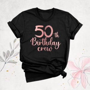 May include: Black t-shirt with a rose gold graphic that says "50th Birthday Crew".