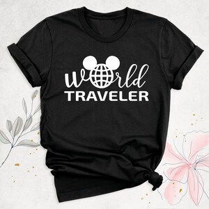 May include: Black t-shirt with a white graphic of Mickey Mouse ears with a globe inside the ears and the text "World Traveler" underneath.