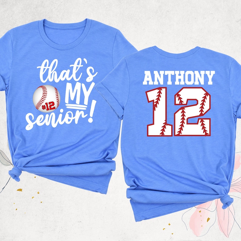 May include: Two light blue t-shirts with a baseball theme. The front shirt says "that's my senior!" with a baseball graphic. The back shirt says "ANTHONY 12" with a baseball graphic.