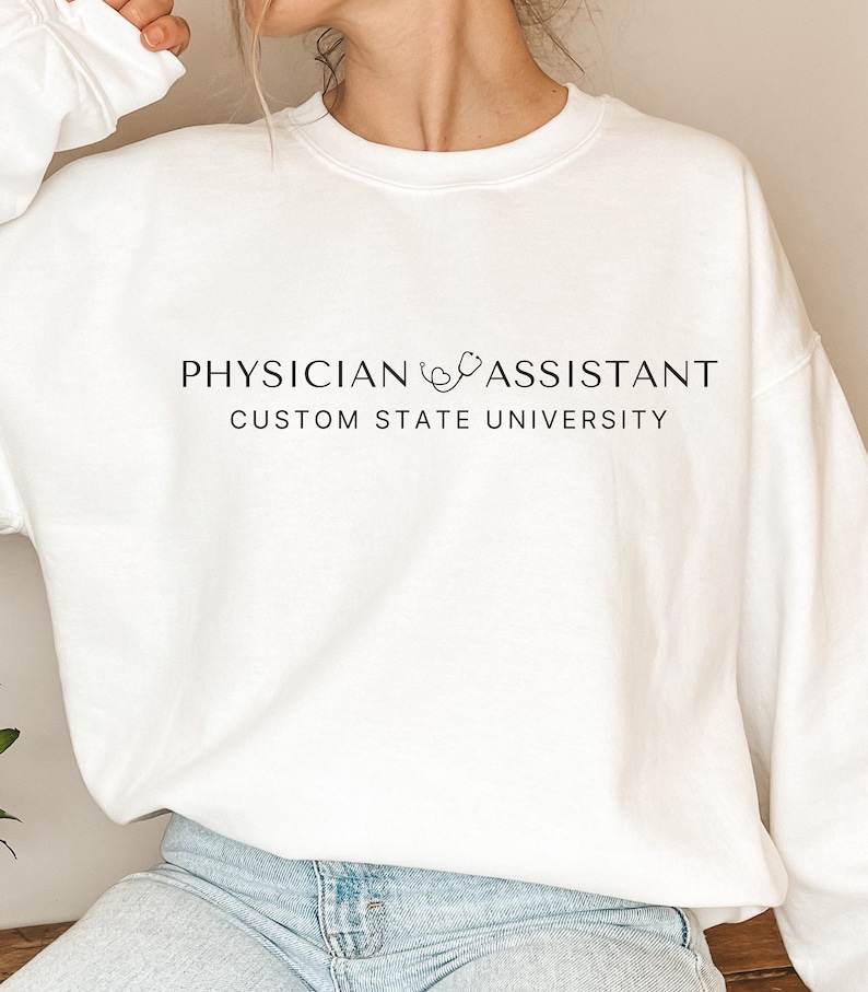 May include: White sweatshirt with the text "PHYSICIAN ASSISTANT CUSTOM STATE UNIVERSITY" and a stethoscope graphic.