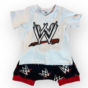 May include: White short-sleeved t-shirt with a red and black WWE logo. Matching black and red shorts with a white WWE logo pattern.