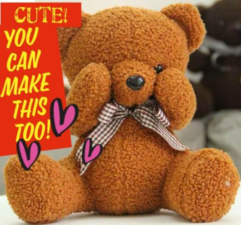 Pu&ograve; includere: Un orsacchiotto di peluche marrone con un fiocco a quadri &egrave; seduto con le zampe che gli coprono gli occhi. L'orsacchiotto ha un'espressione carina sul viso.