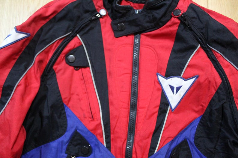 May include: A white ceramic mug with a black handle and the text "But First, Coffee" in a black, handwritten-style font. The mug is on a white surface.