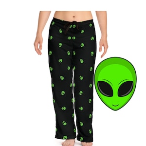 Könnte beinhalten: Schwarze Schlafanzughose mit einem grünen Alien-Gesichtsmuster. Das Alien-Gesicht ist grün mit schwarzen Augen.
