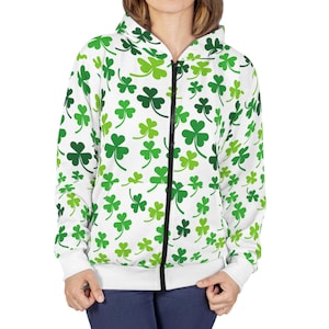 Puede incluir: Sudadera blanca con cremallera y estampado de trébol verde.