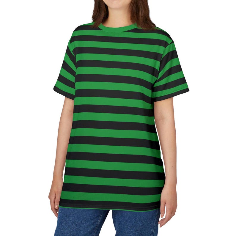 Puede incluir: Una camiseta de rayas verdes y negras con mangas cortas y cuello redondo.