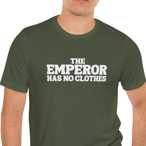 Può includere: Una maglietta verde con testo bianco che dice "L'imperatore non ha vestiti."