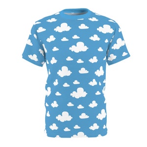 May include: A blue t-shirt featuring a pattern of white cloud shapes against a sky blue background. The short-sleeved top has a crew neck and is designed for casual wear.