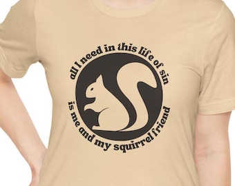 May include: A tan t-shirt with a black circle graphic featuring a squirrel and the text "all I need in this life of sin is me and my squirrel friend".