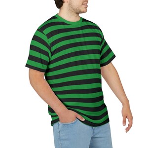 Puede incluir: Una camiseta de rayas verdes y negras con mangas cortas.