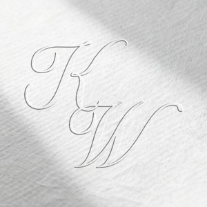 Może przedstawiać: Elegancki, jasnoszary monogram z przeplatającymi się literami "K" i "W" w delikatnym, kursywnym skrypcie. Projekt jest subtelnie wytłoczony na teksturowanym, kremowobiałym papierze, z miękkimi cieniami dodającymi głębi.
