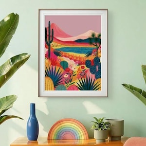 Könnte beinhalten: Ein gerahmter Kunstdruck, der eine lebendige Wüstenlandschaft mit einem blauen See, rosa Bergen und verschiedenen Kakteen in Grün-, Gelb- und Blautönen zeigt. Die Illustration enthält bunte Wüstenflora und eine helle, gesättigte Farbpalette.