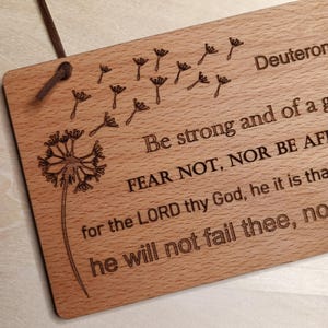 May include: Wooden sign with a dandelion design and the text "Deuteronomy 31:6 Be strong and of good courage, fear not, nor be afraid of them; for the LORD your God, He it is that goes with you; He will not fail you, nor forsake you."