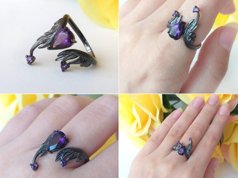 May include: Black ring with a purple gemstone and two wings on either side. The ring is adjustable and can be worn on different fingers.