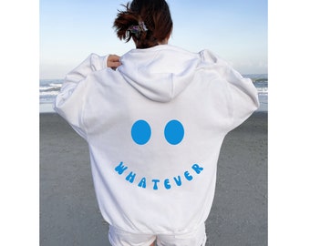 Könnte beinhalten: Weißer Hoodie mit einem blauen Smiley und dem Text "WHATEVER" auf der Rückseite.