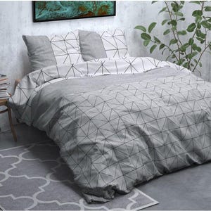 Peut inclure: Une parure de lit à motifs géométriques gris et blancs. L'ensemble comprend une housse de couette et des taies d'oreiller. Le motif présente un réseau de lignes noires formant des triangles sur fond gris. Le lit est fait et prêt à l'emploi.
