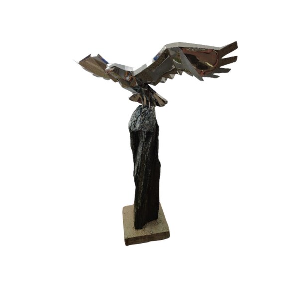 Artistic sculpture of an eagle made of stainless steel, from a column of serpentine stone
