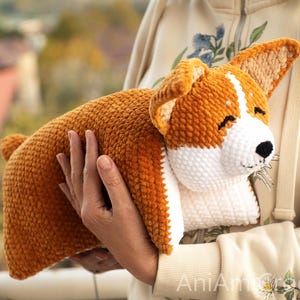 Peut inclure: Un jouet corgi en crochet, r&eacute;alis&eacute; avec un fil textur&eacute; doux de couleur orange et blanche. Le chien pr&eacute;sente de grandes oreilles dress&eacute;es, un visage blanc aux yeux ferm&eacute;s et un petit nez noir. Le jouet est con&ccedil;u avec un point dense et uniforme.