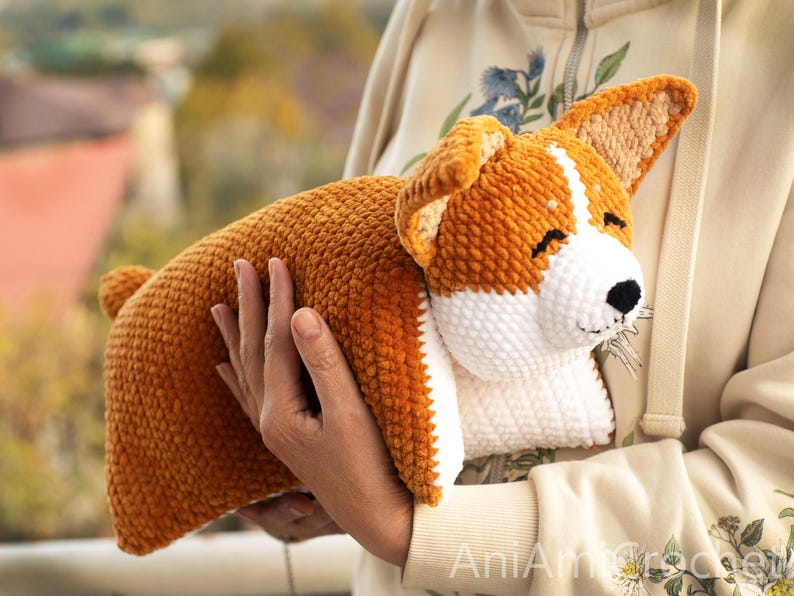 Peut inclure: Un jouet corgi en crochet, r&eacute;alis&eacute; avec un fil textur&eacute; doux de couleur orange et blanche. Le chien pr&eacute;sente de grandes oreilles dress&eacute;es, un visage blanc aux yeux ferm&eacute;s et un petit nez noir. Le jouet est con&ccedil;u avec un point dense et uniforme.