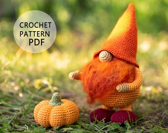 May include: Crochet pattern PDF for a cute orange and red gnome holding a small orange pumpkin. The gnome has a long orange hat and a fluffy red beard. The gnome and pumpkin are sitting on a bed of green grass.