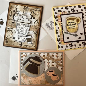 Amateurs de café, ces cartes de vœux artisanales sont faites pour vous ! Papier griffé en couches, agrémenté d'un ruban ou d'une ficelle et de points adhésifs, enveloppe