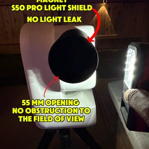 Op de afbeelding: Een witte S50 Pro lichtschild met een zwarte ronde opening. De tekst op de afbeelding luidt: MAGNET S50 PRO LIGHT SHIELD NO LIGHT LEAK en 55 MM OPENING NO OBSTRUCTION TO THE FIELD OF VIEW. Het schild is gemonteerd op een statief.