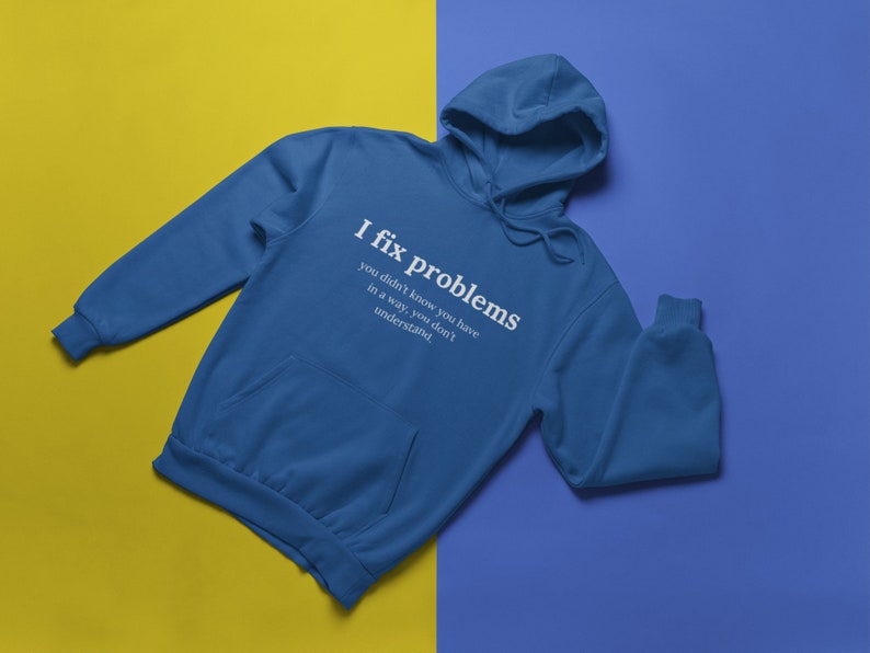 May include: A blue hooded sweatshirt with the text "I fix problems you didn't know you have in a way, you don't understand." printed on the front.